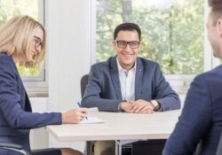 Drei Personen sitzen in einem Meeting