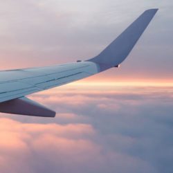 Flugzeugflügel beim Flug im Sonnenaufgang