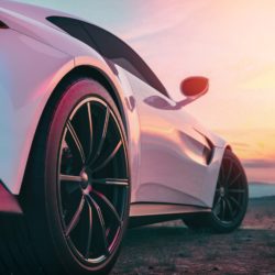 Weißes Auto aus Froschperspektive vor Sonnenuntergang