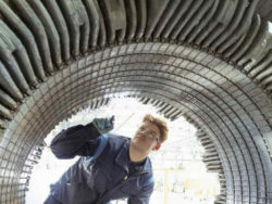 Mann prüft großes elektrisches Bauteil von Innen