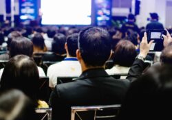 Mitarbeiter:innen hören einer Präsentation zu